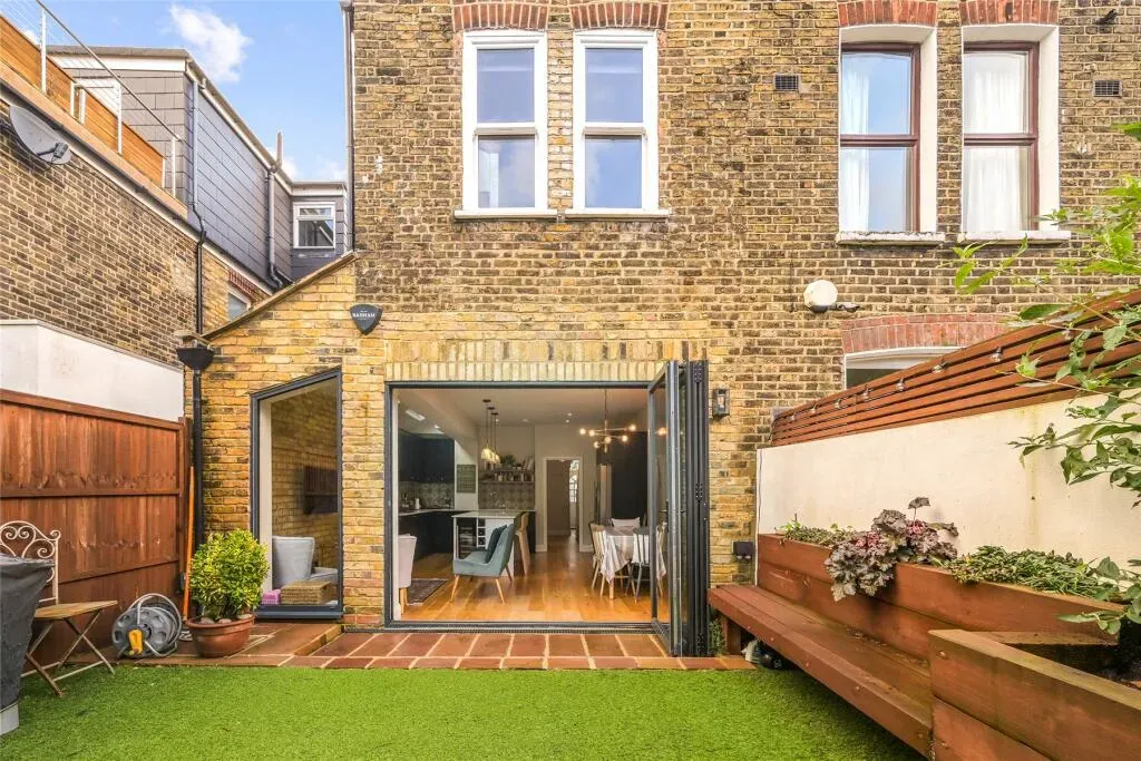 Brick kitchen extension opening onto the garden deck — Chiswick W4
