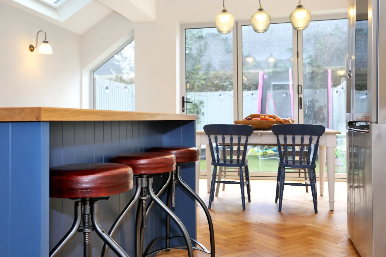 Kitchen island with stools looking towards the garden — Chiswick W4
