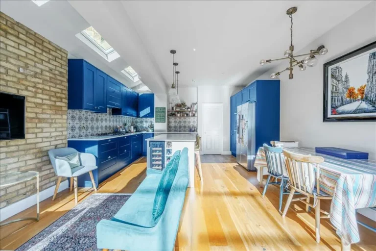 Open-plan kitchen and seating area with blue cabinets — Chiswick W4