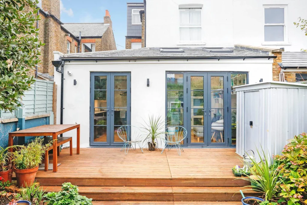 White rear extension with two sets of glazed garden doors and a timber deck