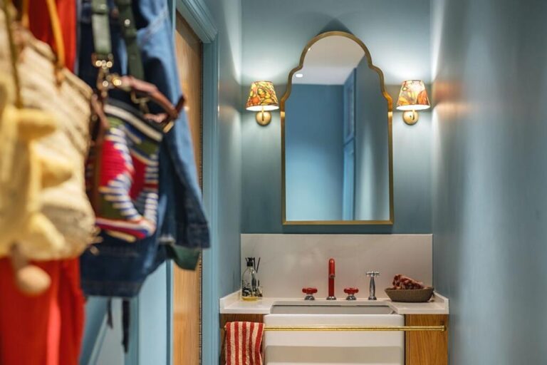 Refurbished bathroom vanity with blue walls, decorative lighting and an oval mirror — Twickenham TW1