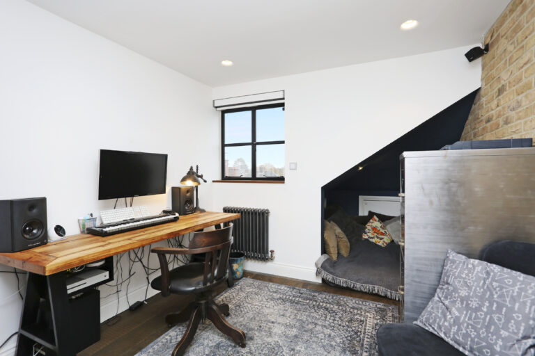 Desk and sofa beside exposed brickwork — Acton W3 9LP