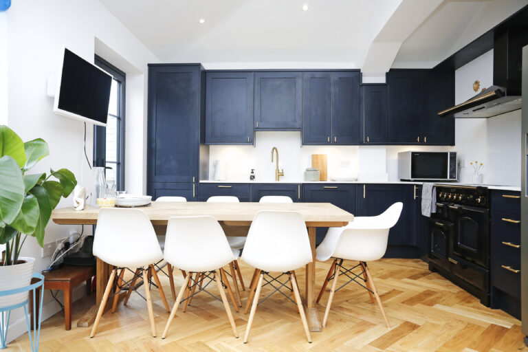 Navy kitchen with timber worktops and dining space — Ealing W13