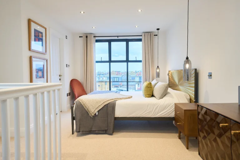 Loft bedroom with a black-framed window and staircase balustrade — Chiswick W4