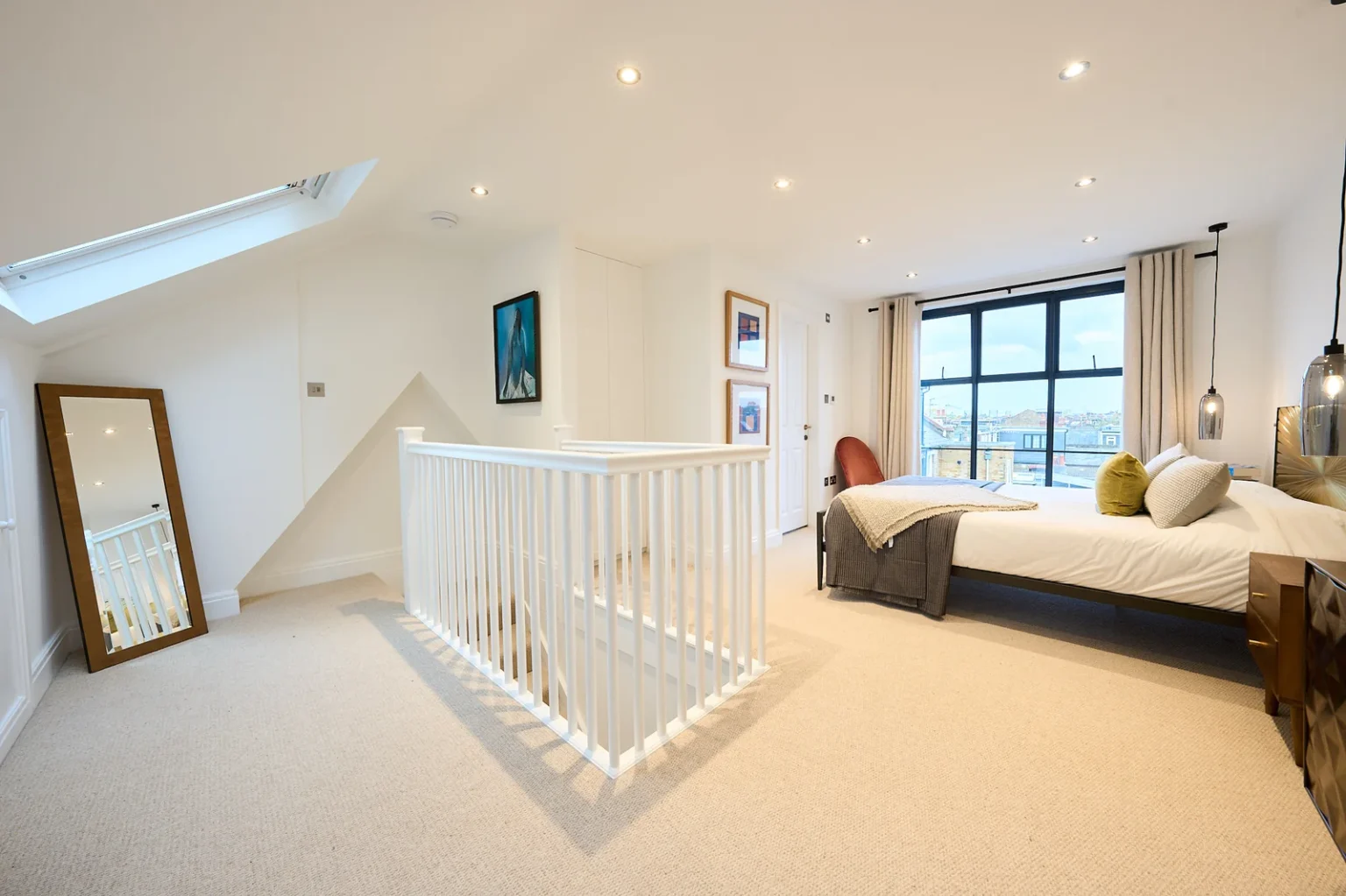 Bright bedroom with staircase and large window view — Chiswick W4