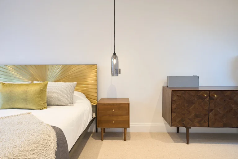 Modern bedroom with wooden furniture and gold headboard — Chiswick W4
