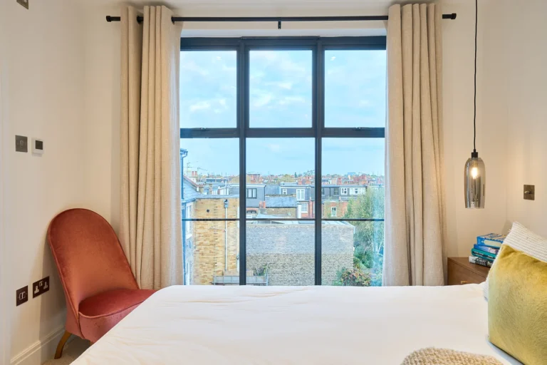 Loft bed and reading chair beside a black-framed rear window — Chiswick W4