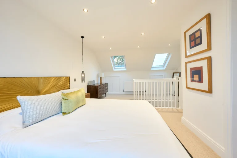 Modern bedroom with skylights and artwork on walls — Chiswick W4