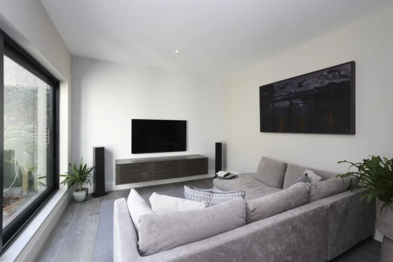 Modern living room with couch, TV, and art — Sheen SW14