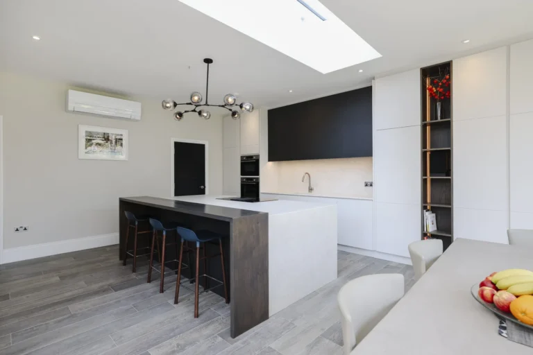 Modern kitchen with island, stools, and fruit bowl — Sheen SW14
