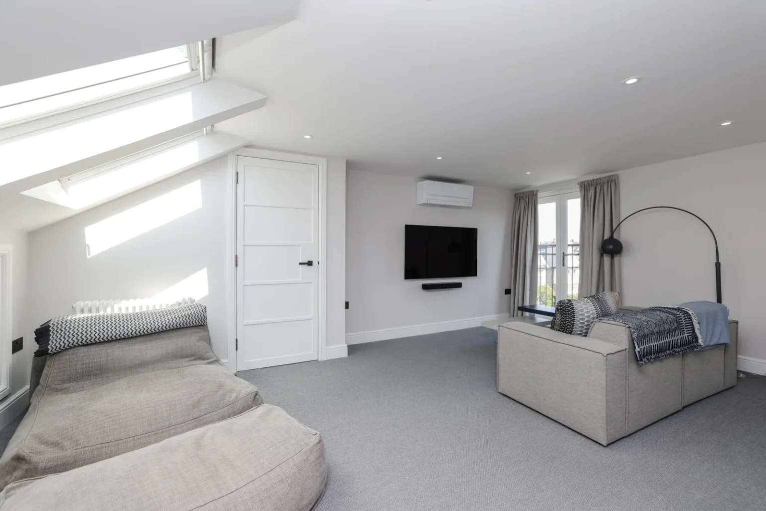 Loft suite with seating, fitted cupboards and rooflights — Sheen SW14
