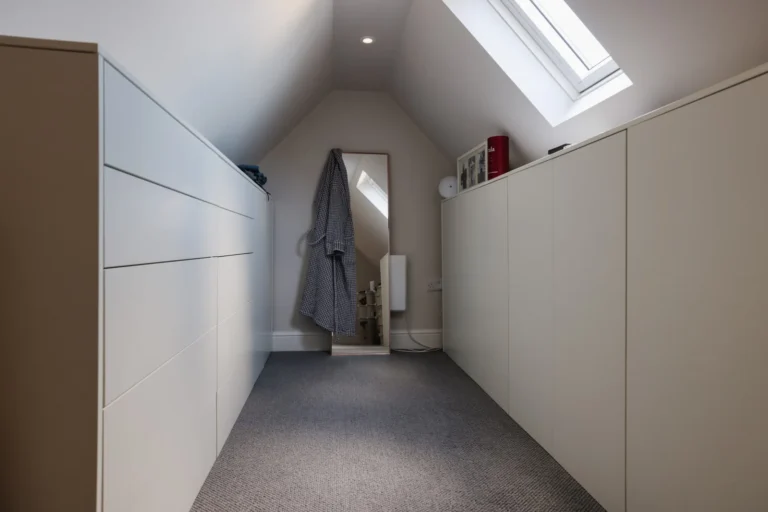 White wardrobe in loft space with skylight — Sheen SW14