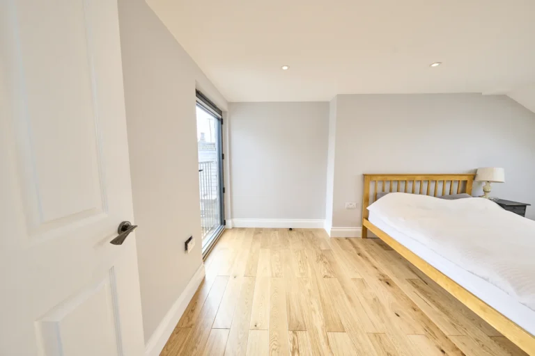 Minimalist bedroom with wooden floor and bed — Kennington SE17
