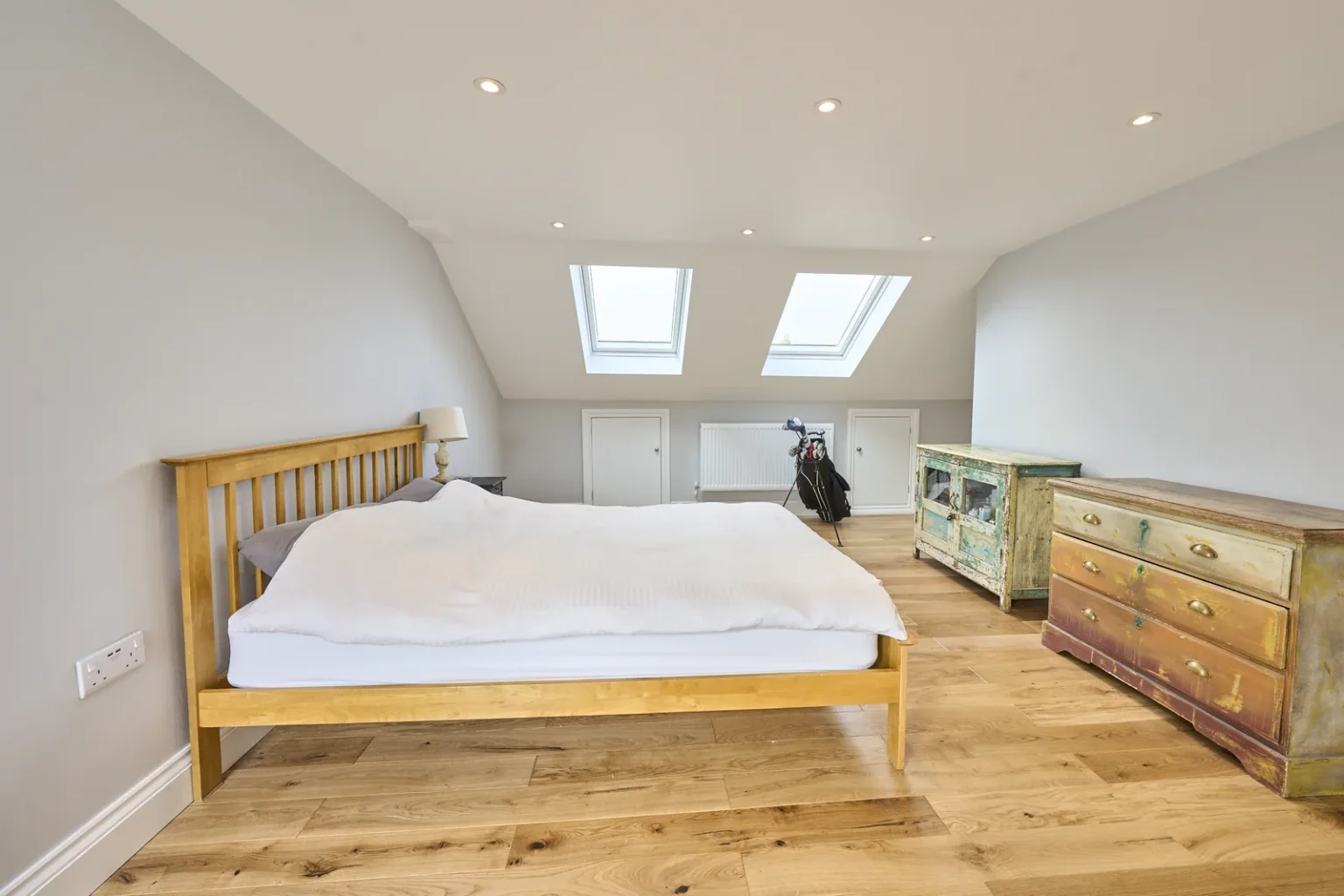 Bright loft bedroom with skylights and wooden furniture — Kennington SE17