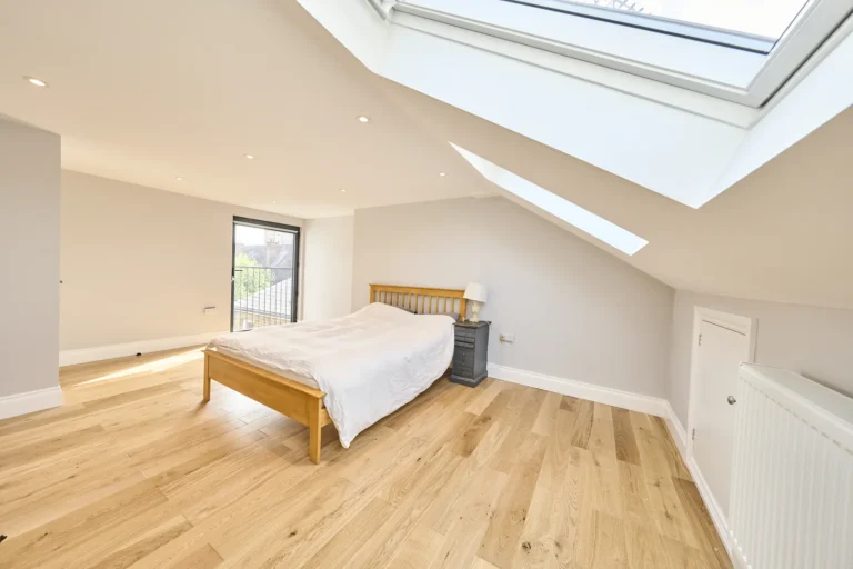 Bright loft bedroom with wooden floor and skylight — Kennington SE17