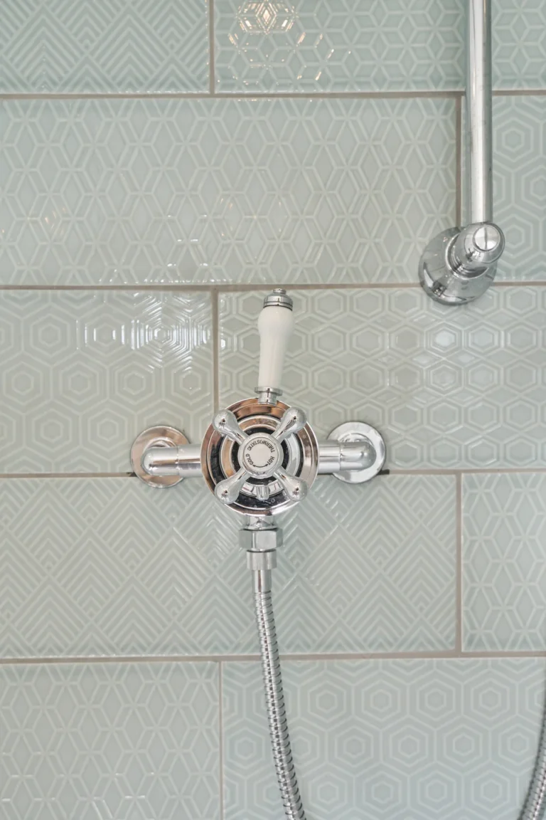 Chrome shower controls against pale green rectangular wall tiles — Kennington SE17