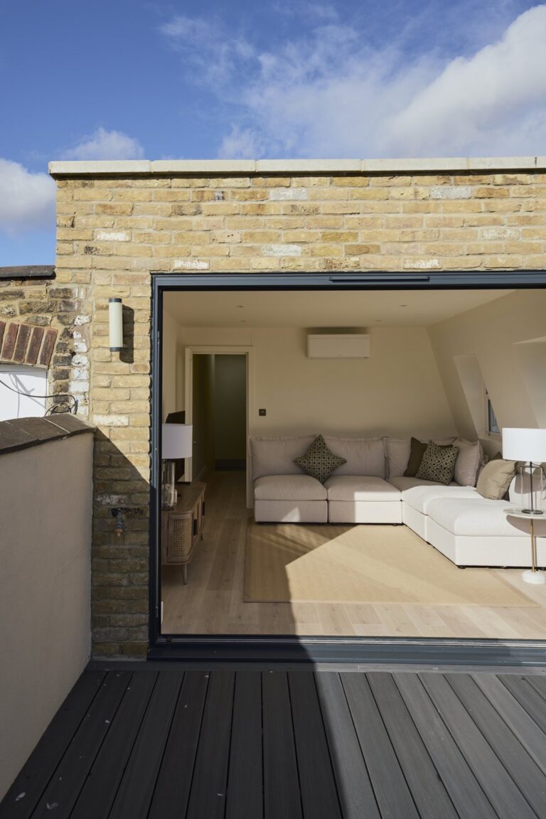 Roof terrace looking through open doors into the loft living area — Clapham SW11
