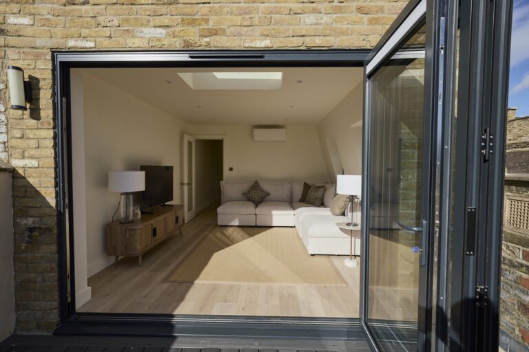 Open terrace doors framing the loft seating area — Clapham SW11