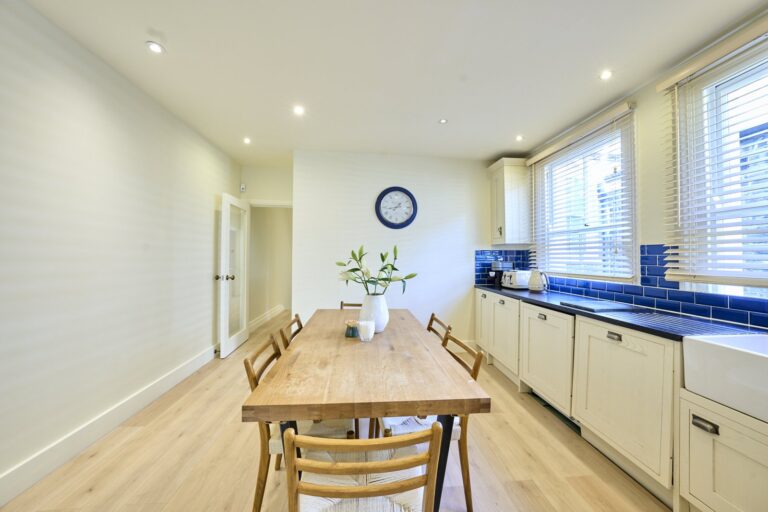 Kitchen and dining area with blue worktops and white cupboards — Clapham SW11