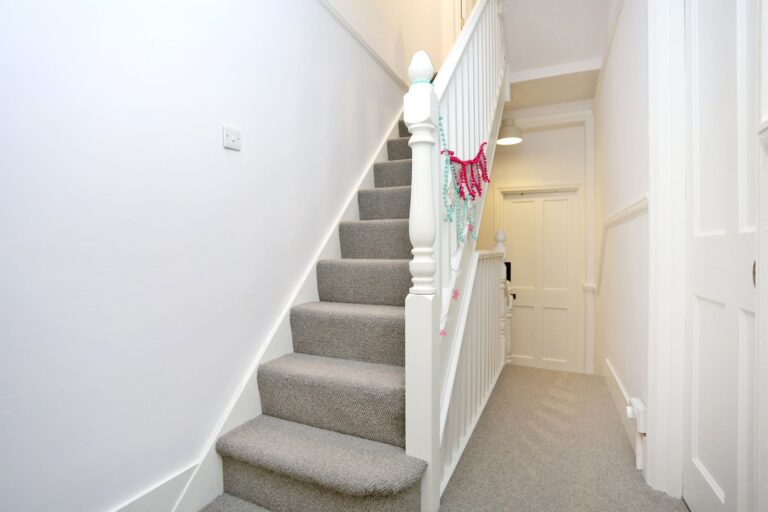 Carpeted stairs with white banister indoors — Isleworth TW7