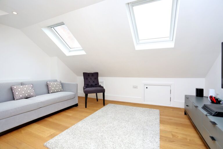 Modern loft living room with skylights and furniture — Brentford TW8