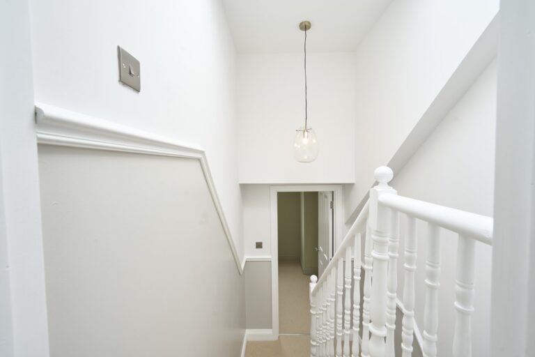 White staircase with hanging light fixture — Balham SW12