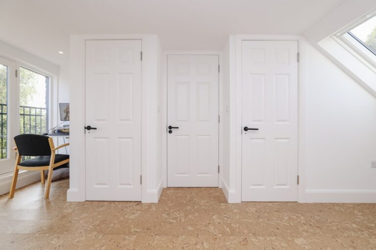 White doors in a home hallway with cork flooring — Acton W3