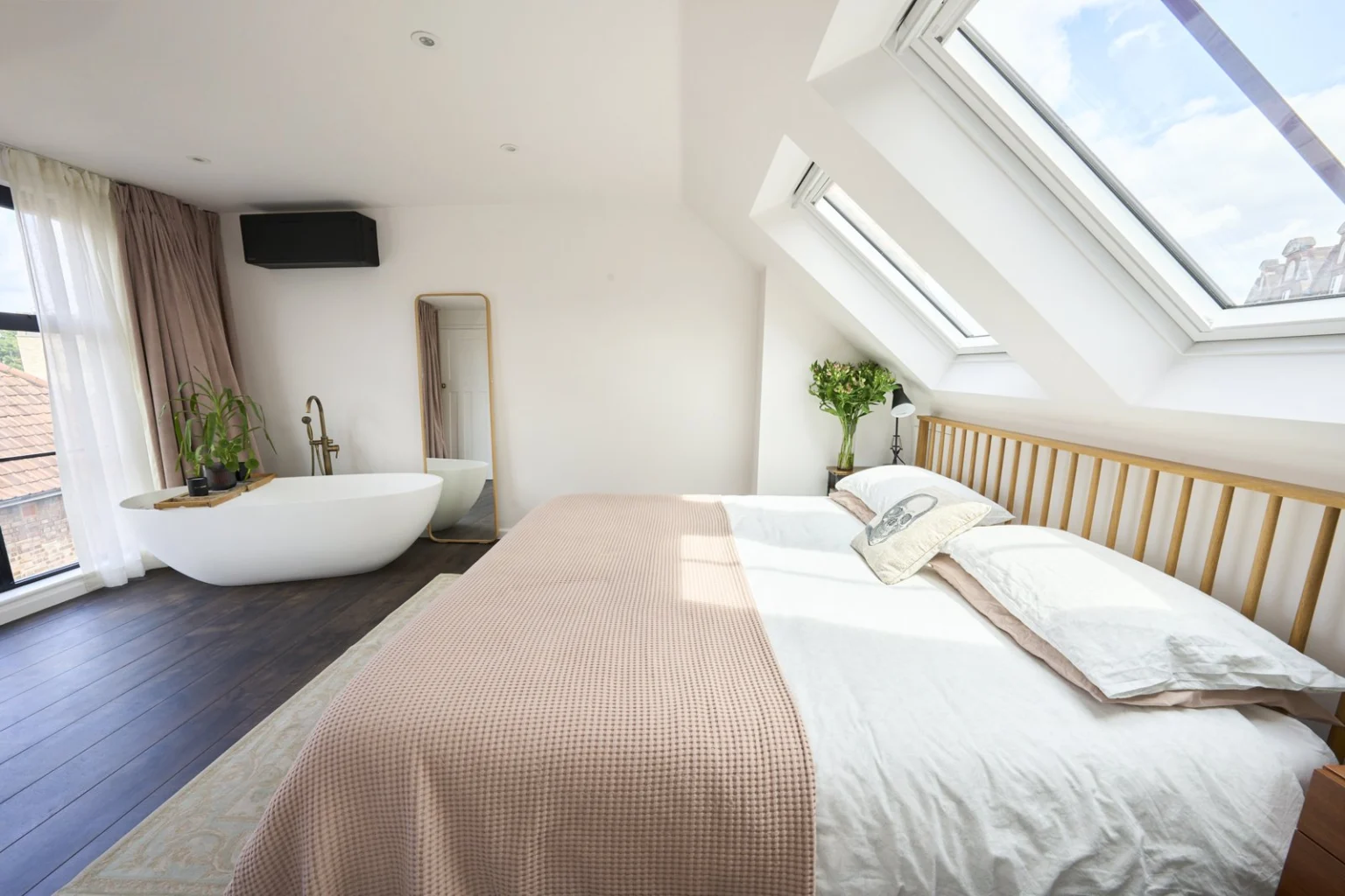 Modern bedroom with bed and bathtub under skylights — Chiswick W4