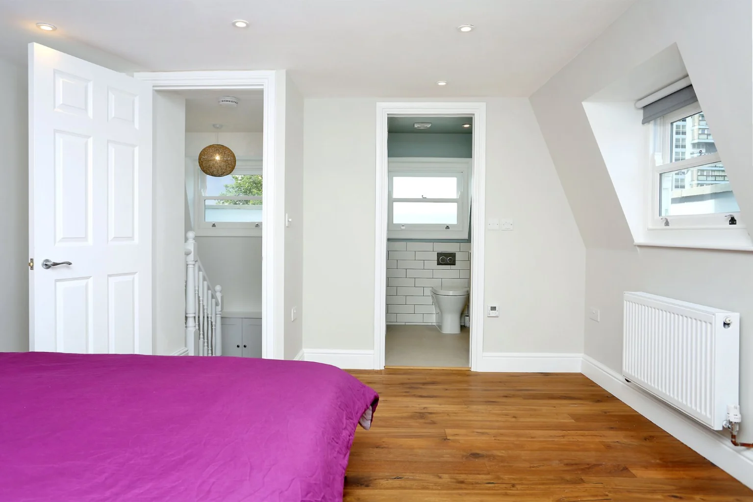 Bedroom with purple bedspread and connected bathroom — Battersea SW8