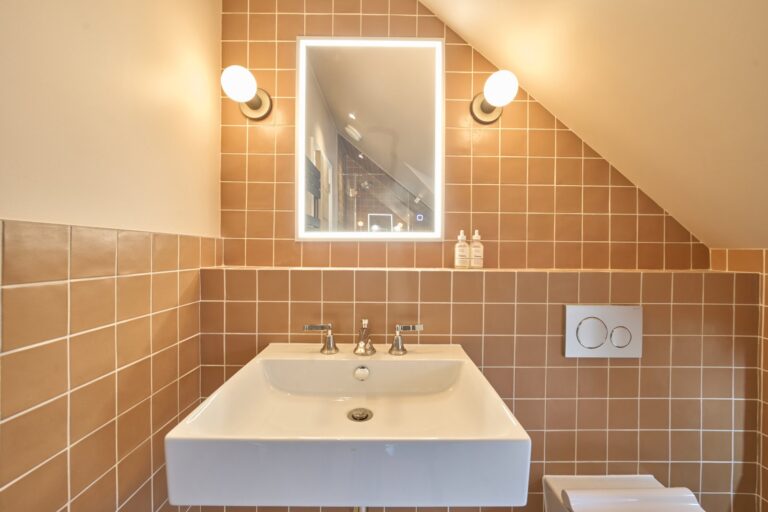Modern bathroom with tiled walls and illuminated mirror — Ealing W5