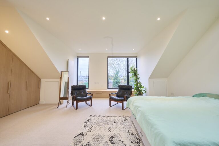 Spacious bedroom with chairs and large window view — Ealing W5