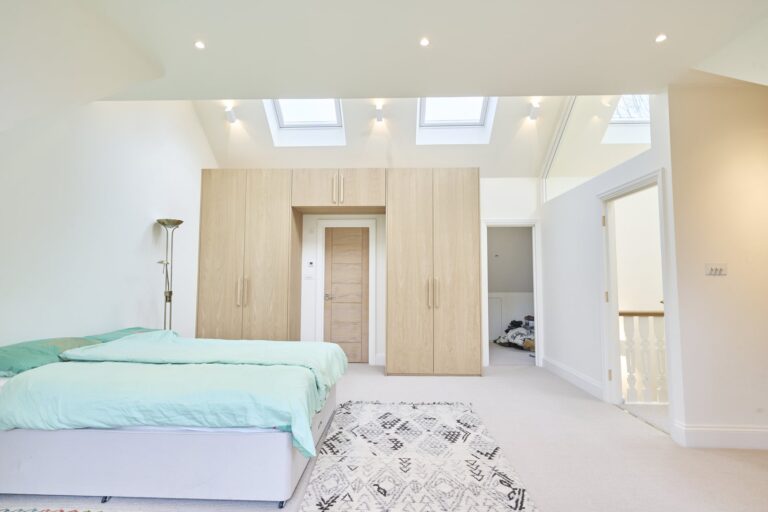 Spacious bedroom with skylights and wooden wardrobe — Ealing W5