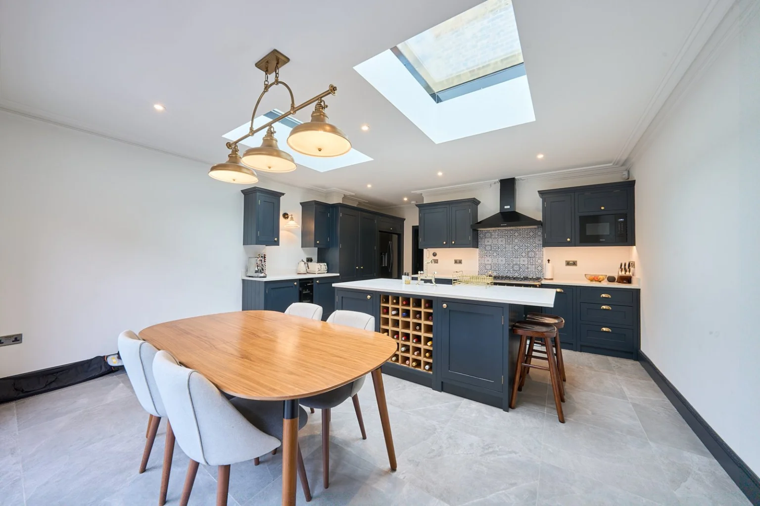 Modern kitchen with skylights and dining table — Ealing W5