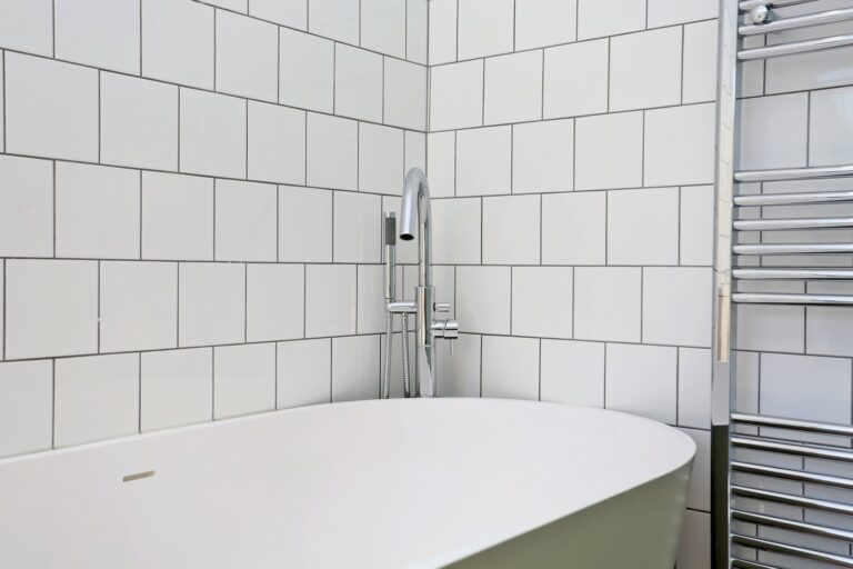 Modern bathroom with white tiled walls and bathtub — Fulham SW6