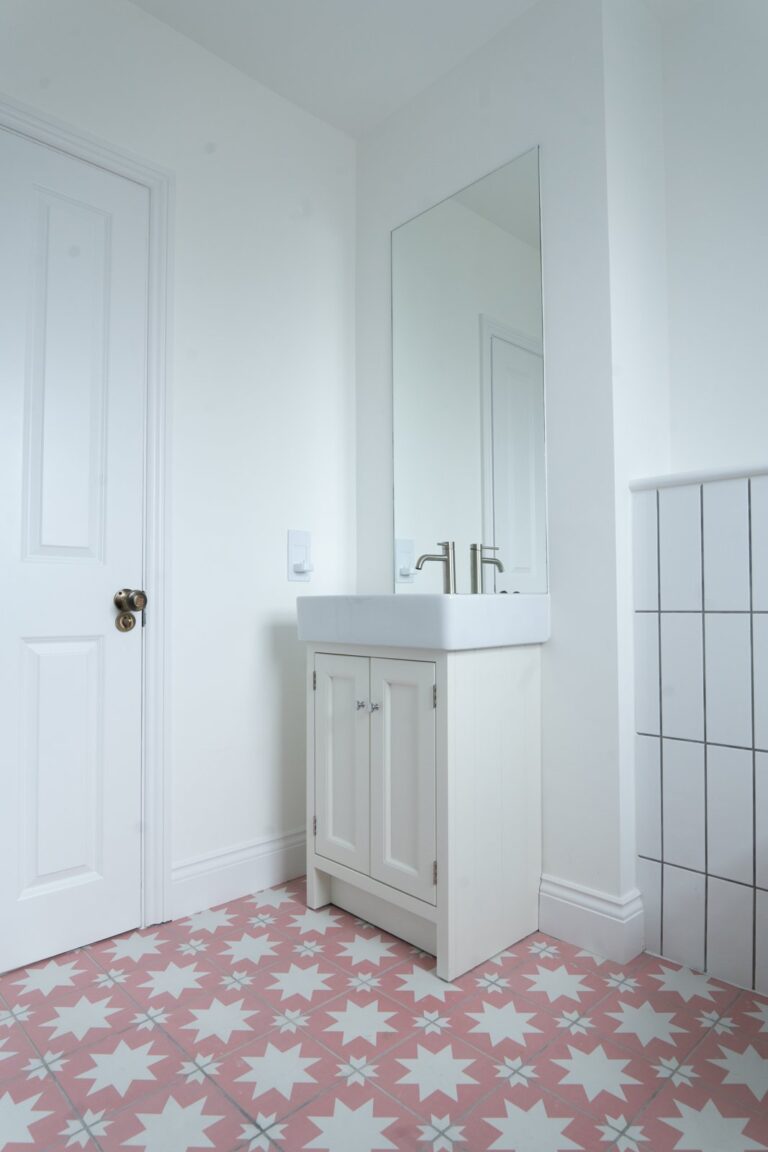 Bathroom with star-patterned pink tiles and white sink — Fulham SW6