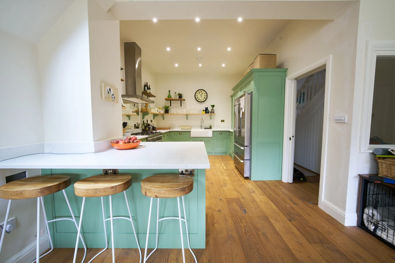 Modern kitchen with wooden flooring and green cabinets — Shepherds Bush W12
