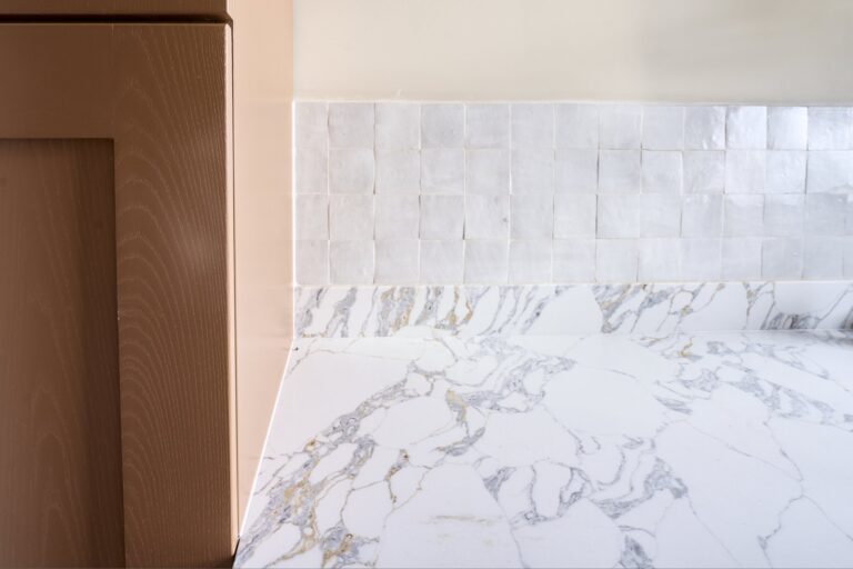 Veined kitchen worktop beside pale tiled splashback — Acton W3