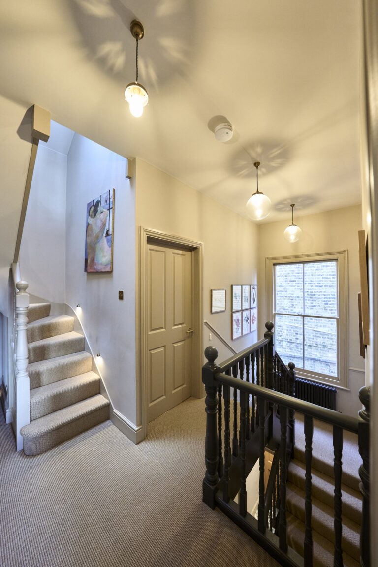 Carpeted staircase and hallway with artwork and lighting — Acton W3