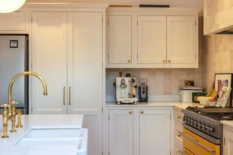 Modern kitchen with white cabinets and brass faucet — Twickenham TW1